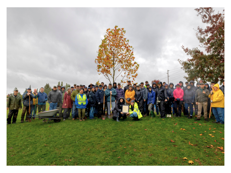 Group picture of volunteers in a park after planting new trees.